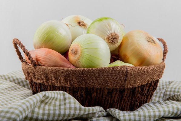 side view of onions in basket on plaid cloth on white background 2 - Монастырская кухня: суп из зелени и чинёная репа