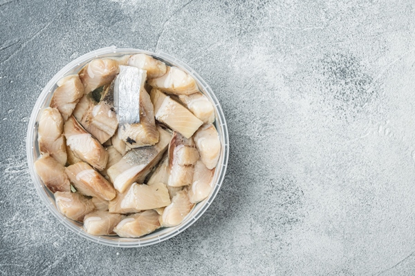 sliced herring in oil marinated on gray table top view flat lay - Блинчики из шпината с начинкой