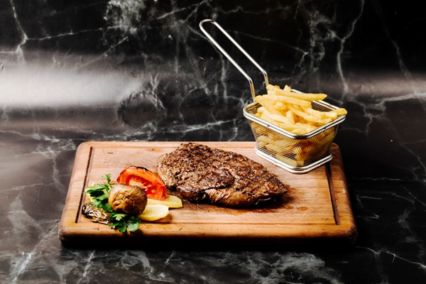 tenderloin steak with grilled vegetables and french fries on a wooden board 1 - Бифштекс с картофелем