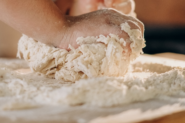 the cook prepares the pizza dough cooking a man kneads the dough with his hands for making pizza in the oven - Монастырская кухня: грибные вареники, овсяный кисель