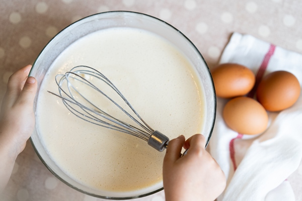 the process of making dough for pancakes with ingredients on a light table eggs and flour are whipped with a mixer 6 - Пирог "Гроздь винограда"