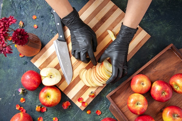 top view female cook cutting apples on a gray surface - Монастырская кухня: пшённые галушки, ореховая тарталетка