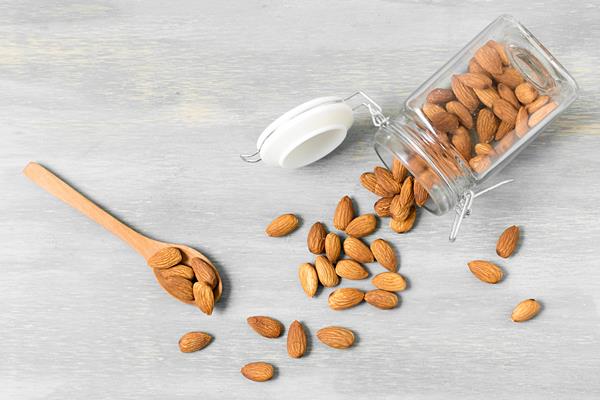 top view of almonds in jar with spoons - Овсянка с ягодами и миндалём без варки