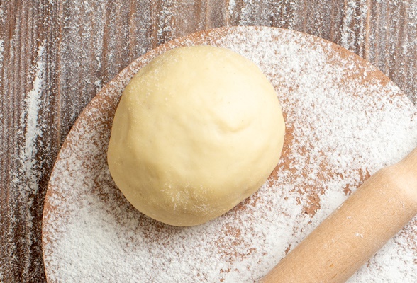 top view raw dough piece with flour on wooden desk meal flour bake dough - Монастырская кухня: пшённые биточки с грибами, жареные пирожки с повидлом (видео)