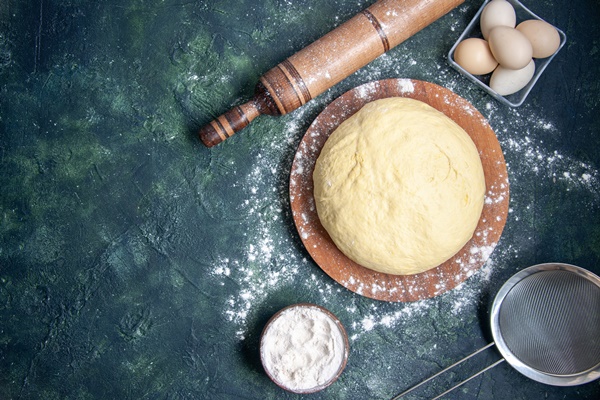top view raw dough with white flour and eggs on dark blue background pastry bake cake pie raw fresh oven dough hotcake - Пирожки жареные дрожжевые