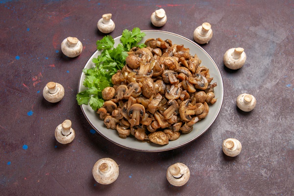 top view yummy cooked mushrooms with greens on dark desk - Монастырская кухня: грибной бульон с расстегаями, кулеш