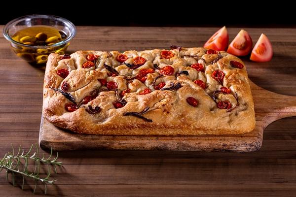 traditional italian focaccia with cherry tomatoes black olives and rosemary - Фокачча с помидорами и луком