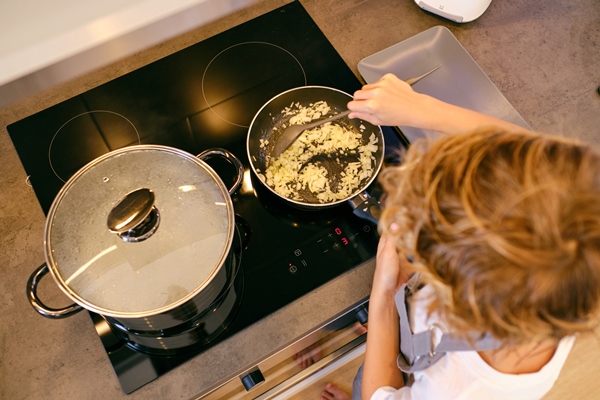 unrecognizable person stirring onion in pan on stove top - Монастырская кухня: пшённая каша с квашеной капустой, фасолевая лапша (видео)