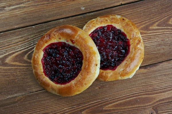 vatrushkai patties with cowberry russian pastry on a wood surface - Пресное бездрожжевое тесто