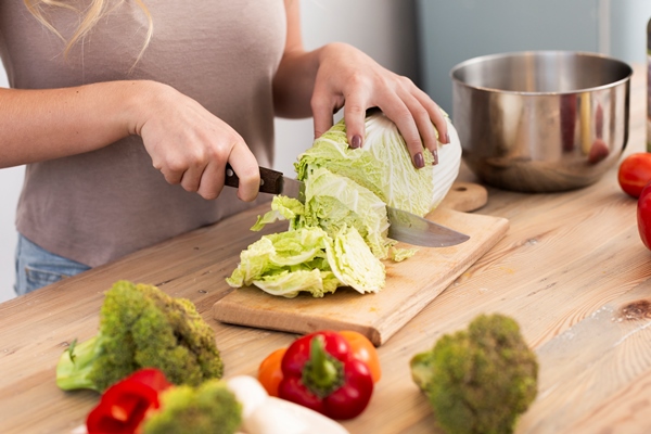 woman cutting the iceberg cabbage - Постный салат с пророщенным машем