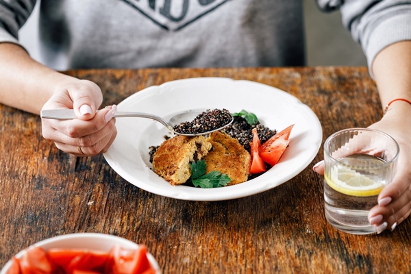 woman having lunch fried prunes oat cutlets black quinoa - Котлеты из разностей с маслом