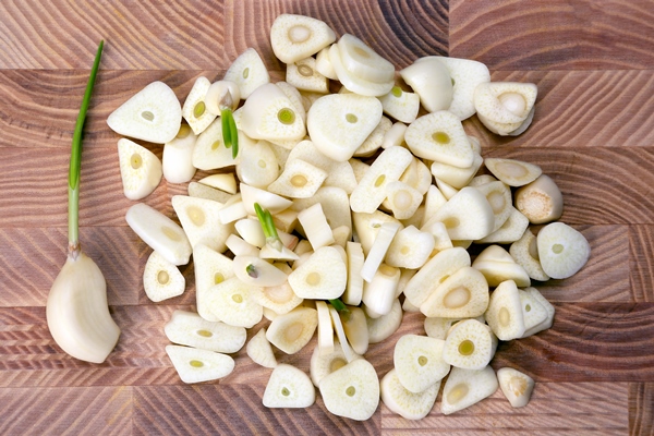 chopped garlic on wooden board - Бабагануш из баклажан