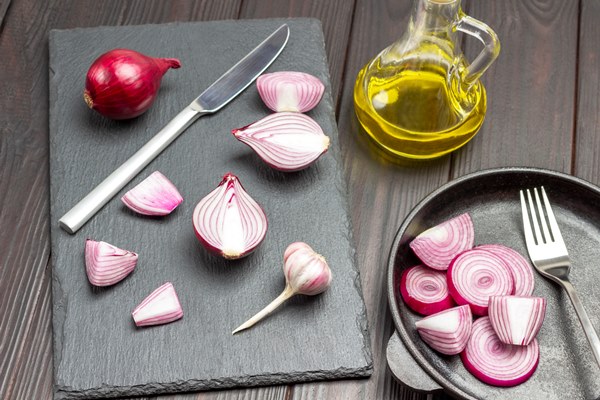chopped onion and knife on cutting board sliced purple onions and fork in frying pan bottle of olive oil dark wooden background top view - Шкара классическая