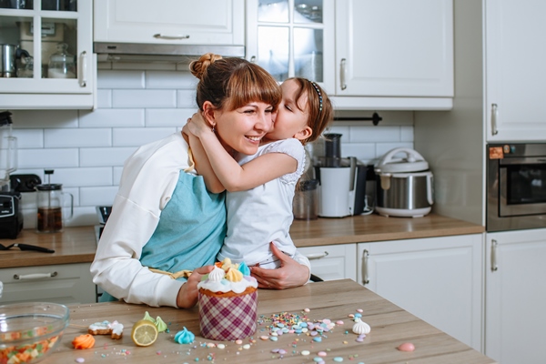 daughter kissing mother at the time of cooking easter cake - Куличи александрийские