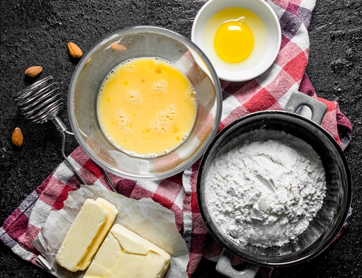 flour with butter and egg on napkin on black rustic table - Кулич быстрый с лимоном и ванилином