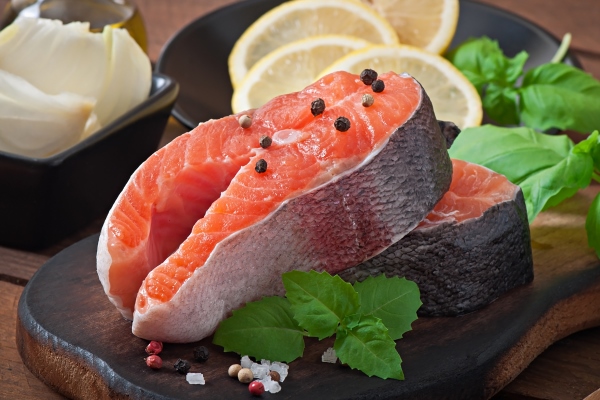 fresh and raw steaks trout on a wooden cutting board with sliced lemon rosemary and pepper - Бастурма-шашлык из рыбы