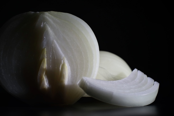 fresh onion bulbs on black background bulb onion is rich in vitamins useful spring onion peel on a dark background raw sliced onions - Корюшка маринованная