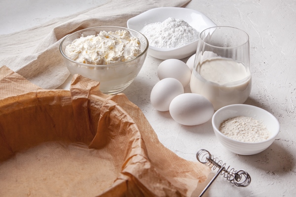 ingredients for making basque spanish burnt saint sebastian cheesecake cream cheese sugar eggs flour cream baking dish covered with paper recipe step by step flat lay top view - Пастьера