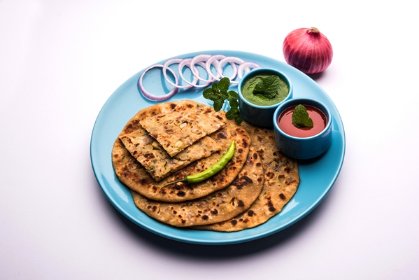 onion parotha or pyaj parantha or kanda paratha served with tomato ketchup and green chutney - Постные луковые лепёшки