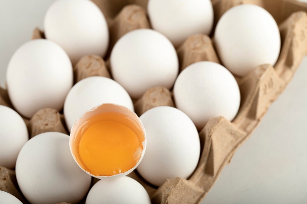 raw chicken eggs in egg box on a white surface - Суп овсяный протёртый на молоке с яйцом
