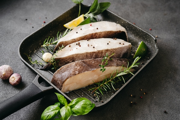 raw halibut fish steaks with herbs and lemon prepared for cooking in a grill pan healthy omega 3 unsaturated fats source good for brain and mental clarity - Камбала жареная