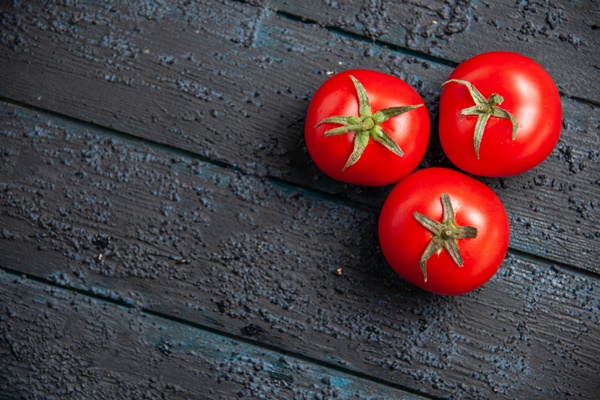 top close up view tomatoes on table three red ripe tomatoes on wooden grey table - Запечённый морской окунь с картофелем