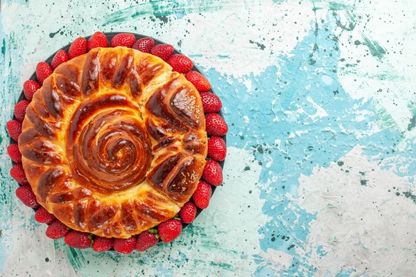 top view round delicious pie with fresh red strawberries on blue desk - Австрийский пасхальный рулет