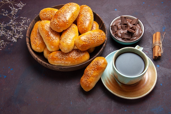 top view sweet patties with cup of tea and chocolate on a dark background pastry dough meal food patty tea - Начинка из риса или пшена с изюмом