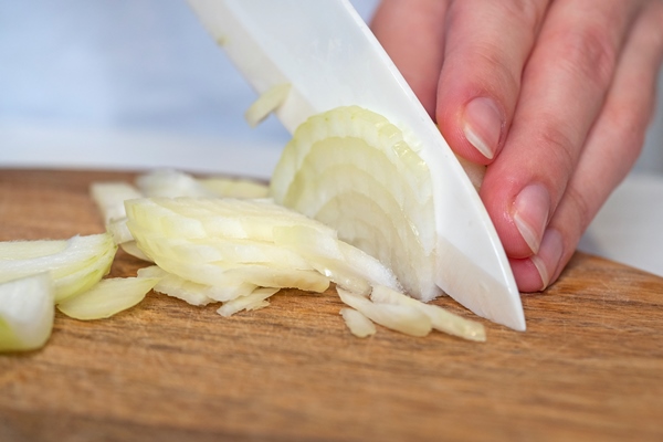 white onions are cut with a knife on a wooden board the concept of cooking selective focus - Лечебный стол (диета) № 3 по Певзнеру: таблица продуктов и режим питания