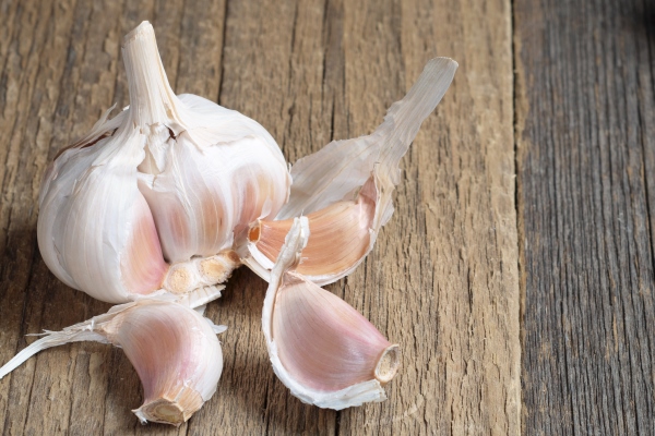 whole and cloves of garlic on old wooden background - Чечевичный суп "Мерджимек Чорбасы"