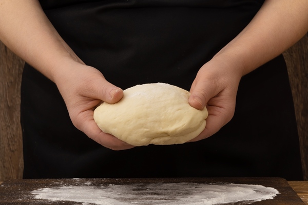 woman preparing yeast dough for pizza or pastry - Пасхальные крестовые булочки