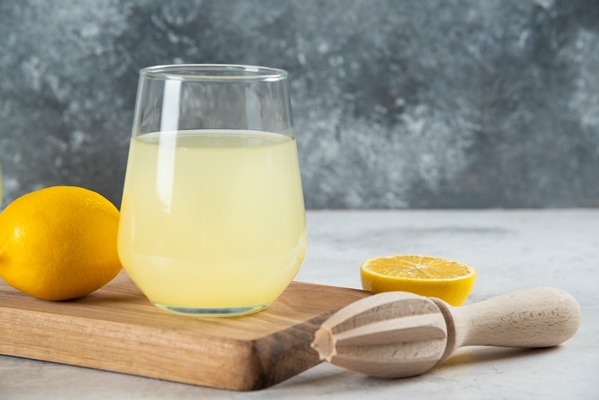 a glass cup of lemonade and wooden reamer - Яйца, фаршированные пастой из сныти