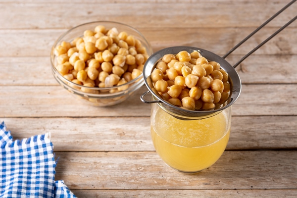 chickpea water aquafaba on wooden table chickpea water is a substitute for eggs in pastries - Хумус с черемшой