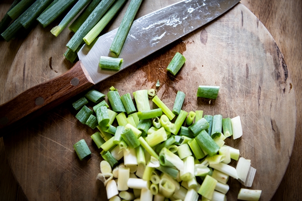 chopped scallion on a cutting board - Пирожки с черемшой и яйцом