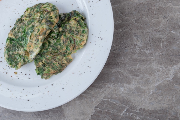 egg cutlet with greens on white plate - Жареные одуванчики с говядиной