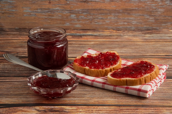 plum confiture in a glass jar with toast breads on a kitchen towel - Повидло из лопуха без сахара