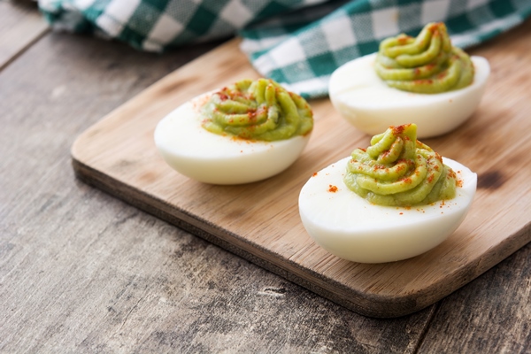 stuffed eggs with guacamole on wooden table 1 1 - Яйца, фаршированные пастой из сныти