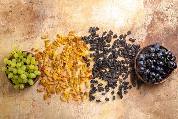 top close up view grapes black and green grapes in bowls green and black raisins on the table - Квас из одуванчиков