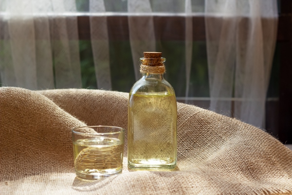 vegetable oil in a bottle glass on burlap canvas fabric background - Сныть тушёная