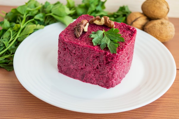 vitamin salad of boiled beets in the form of a square with walnuts on a white plate - Свекольный салат с лебедой