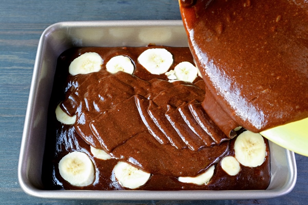 cake batter of chocolate banana cake being poured into cake pan - Шоколадный пирог с бананами