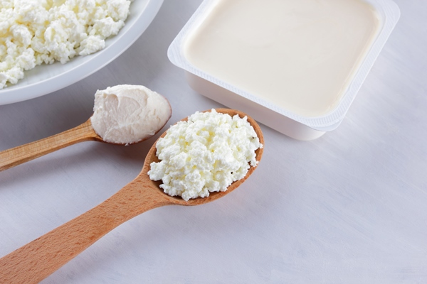 dairy products on a white board cottage cheese cream and soft cheese on a white background - Творожный десерт с клубникой