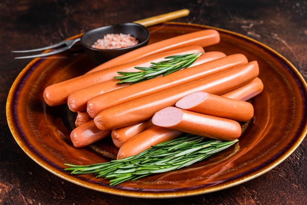 frankfurter raw sausages in a rustic plate with herbs - Весёлые сосиски