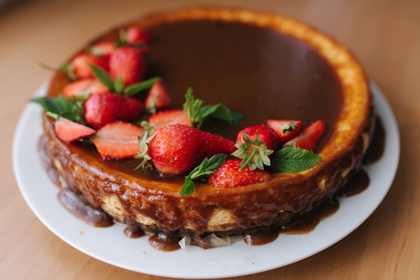 tasty strawberry tart decorated with mint leaves on wooden table caramel glaze on top of tart - Творожный десерт с клубникой