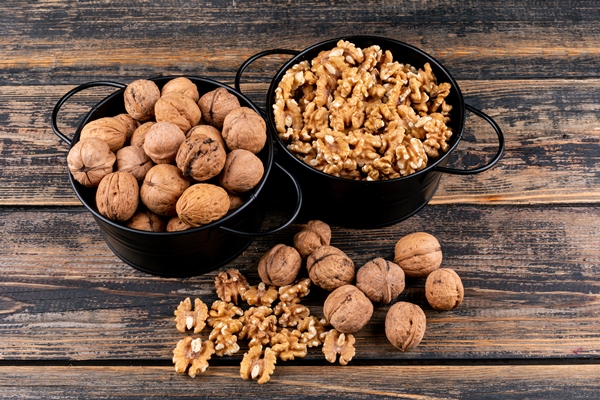 top view walnuts in baskets on wooden horizontal - Сливовое варенье с орехами