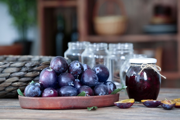 tray with plums and jar of jam on table - Сливовое варенье с орехами