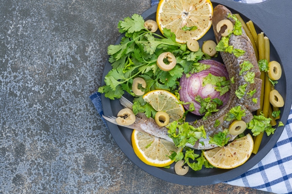 fish and vegetables on a wooden pan on a tea towel - Лимонная закуска