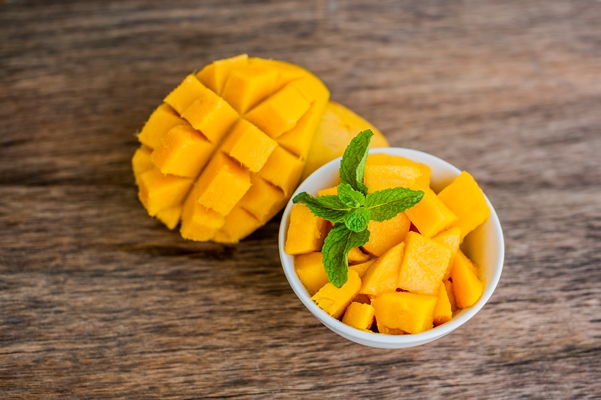 mango fruit and mango cubes on the wooden table - Острый фруктовый салат