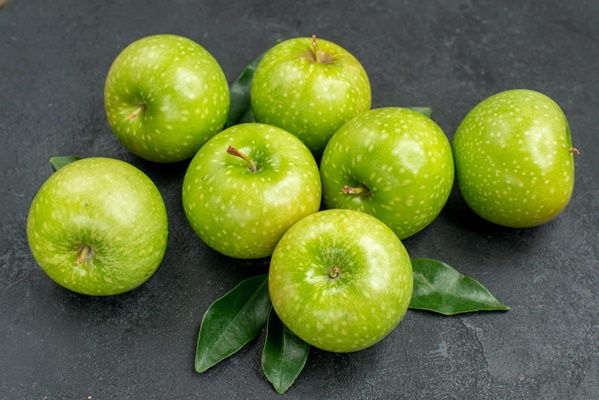 side close up view apples seven appetizing green apples with leaves on the table - Суп из лосося с яблоками