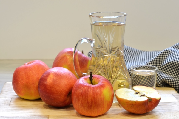 apple cider vinegar in glass bottle and fresh apples on wooden background - Острая закуска из кабачков "Тёщин язык"